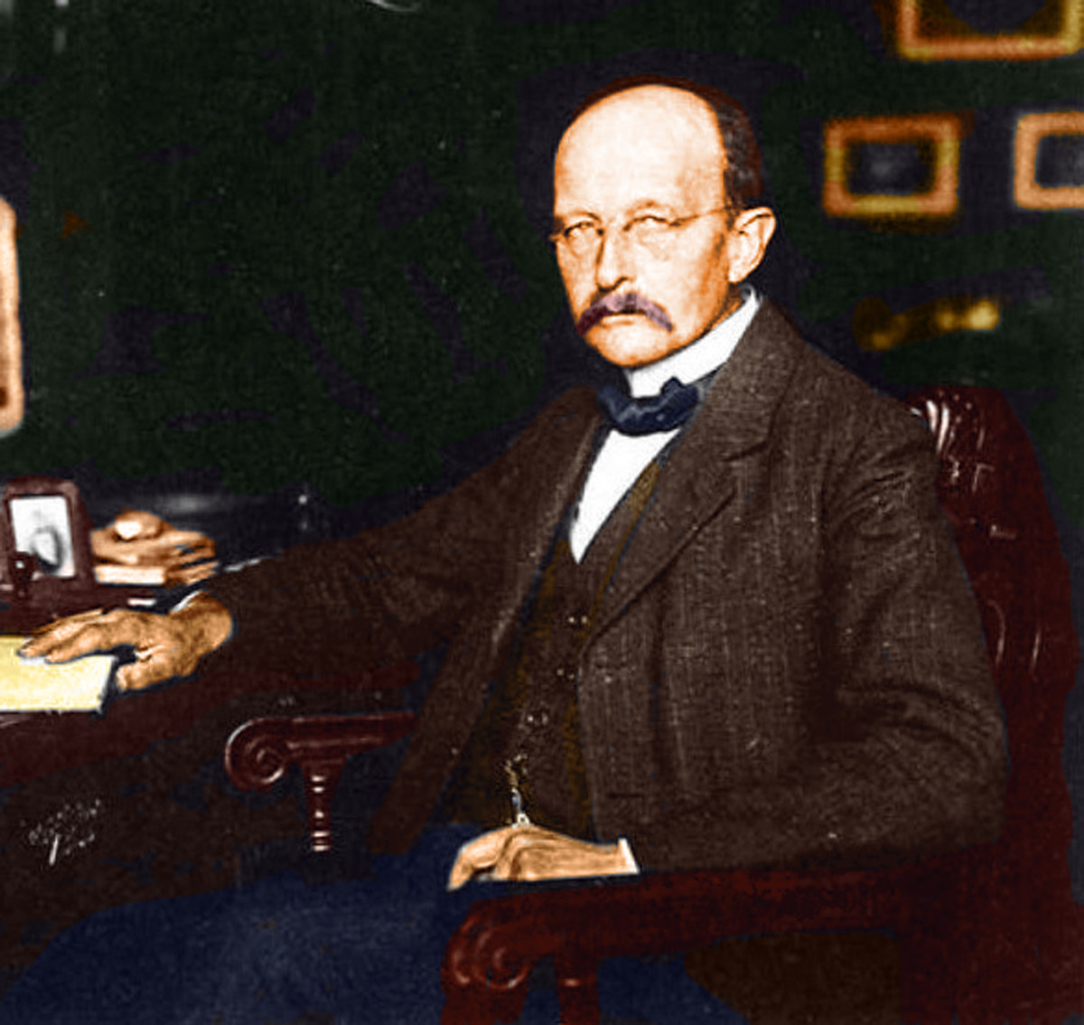 Max Planck circa 1919 sitting at his desk.