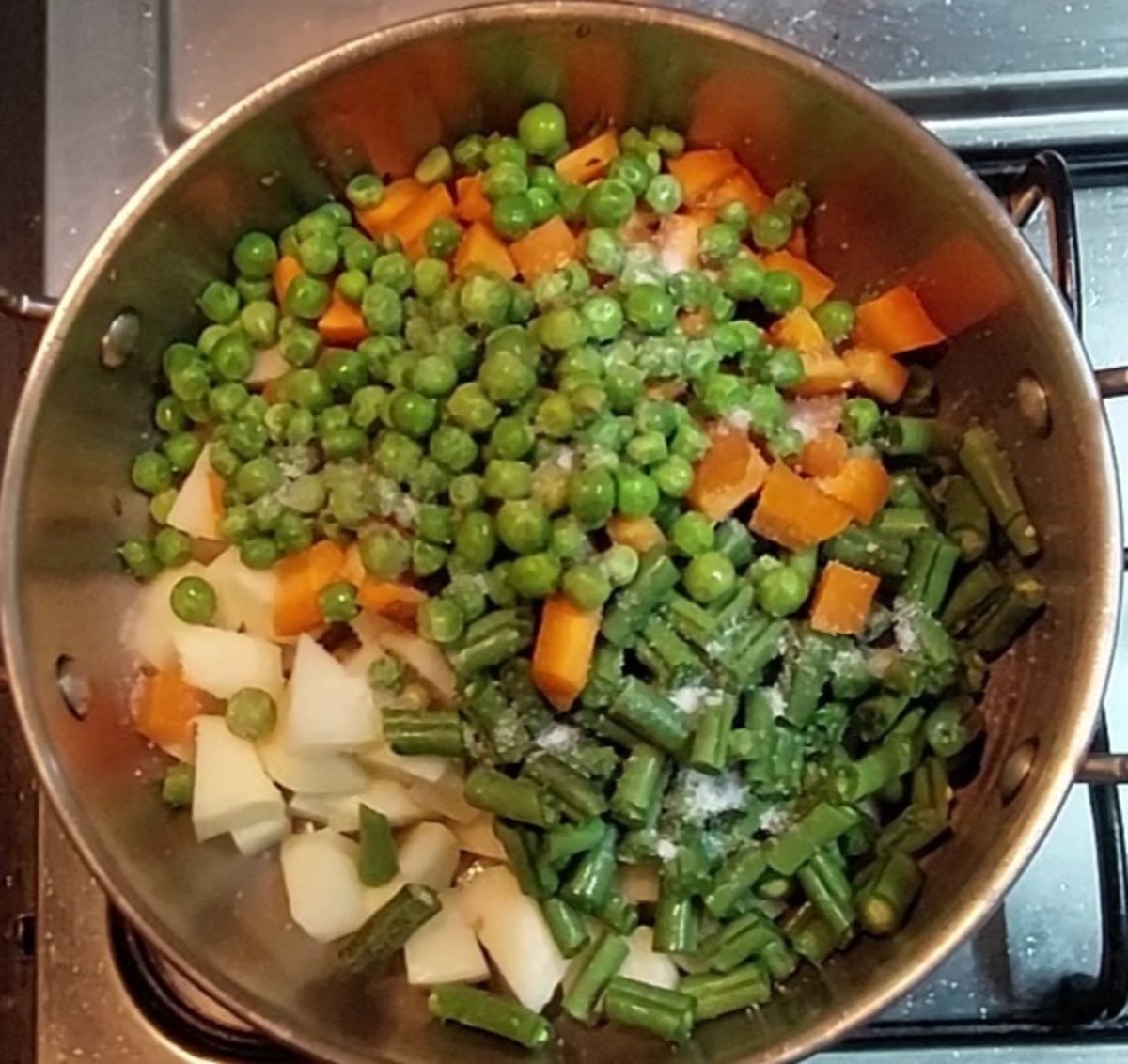 Add 1 cup peeled and cubed potatoes, 1 cup chopped French beans, 1 cup cubed carrots and 1/2 cup peas. Add salt to taste.