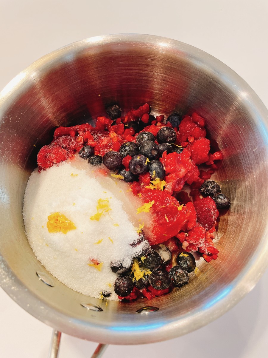 In a small-sized pan, combine the frozen raspberries, blueberries, sugar, lemon zest, and lemon juice.