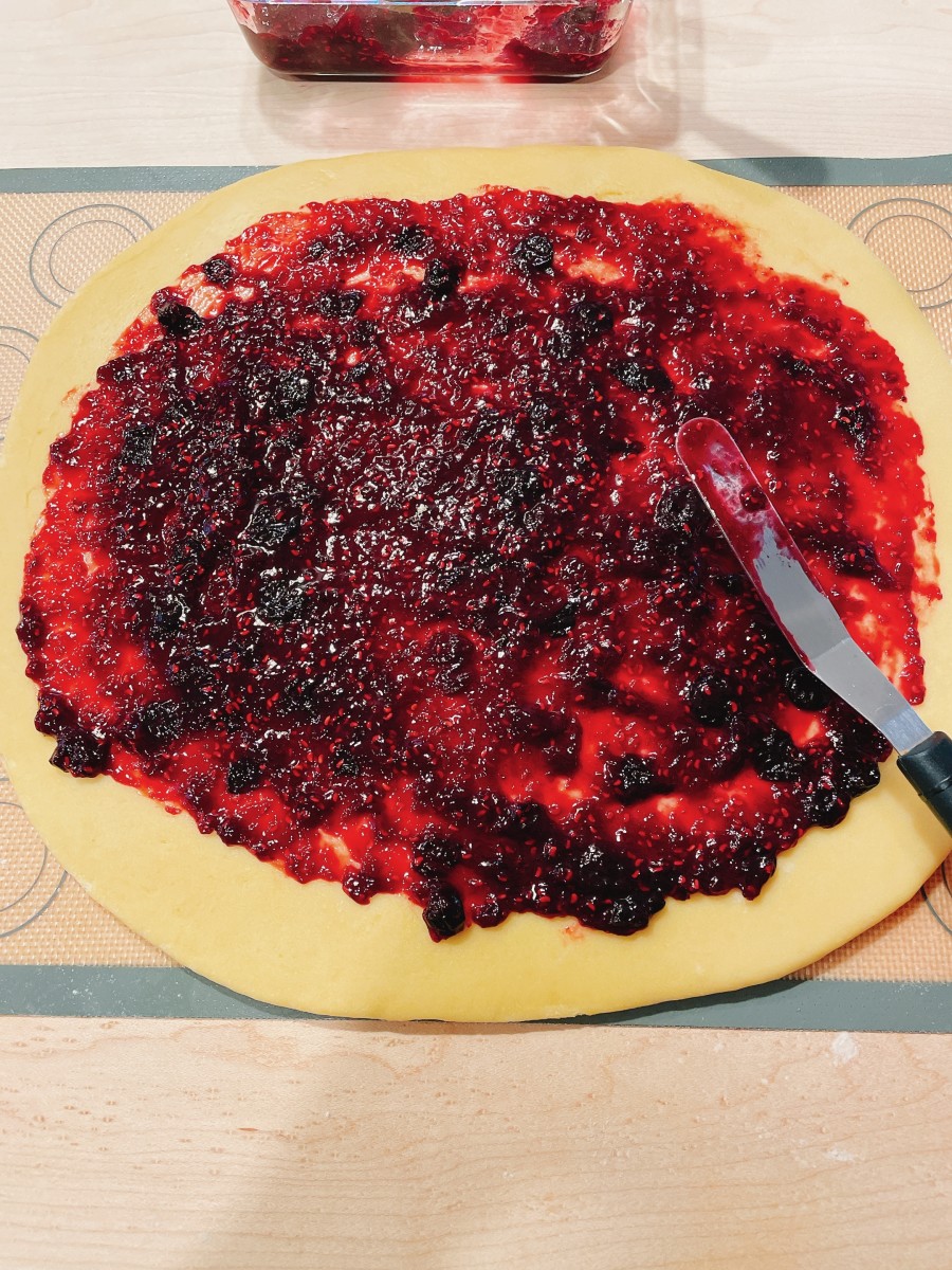 Using a spatula or a knife, spread the jam filling in an even layer over the dough.