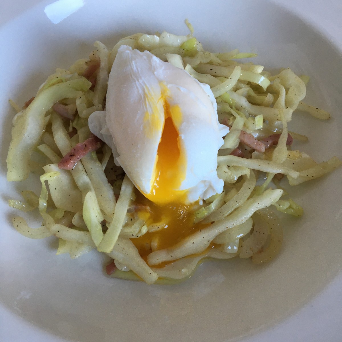 Poached duck egg on stir fried cabbage and bacon