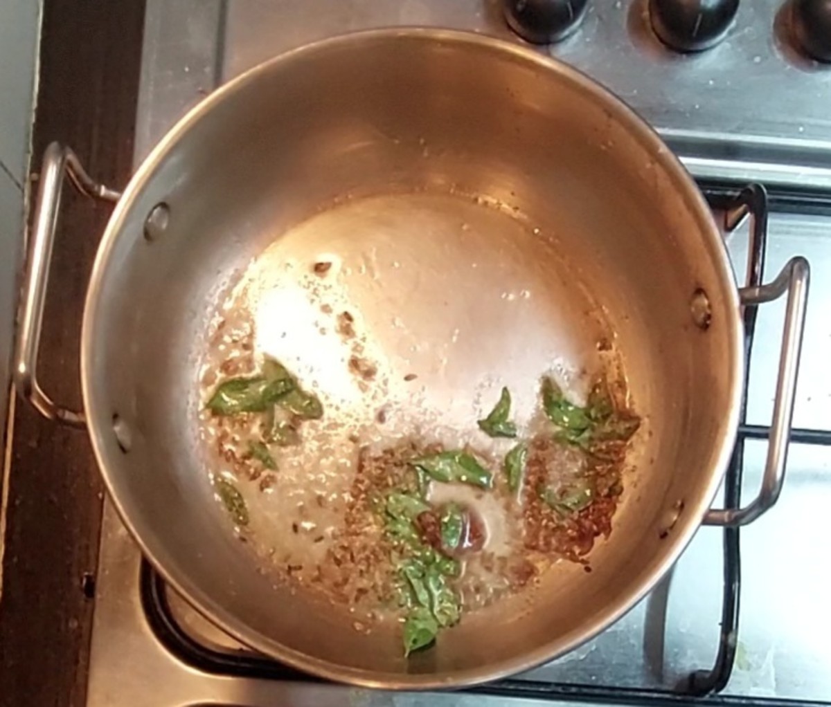 In a pan, heat 2 tablespoons oil and splutter 1/2 teaspoon cumin seeds. Add 2-inch-long piece of cinnamon, a sprig of curry leaves and 1/4 teaspoon hing (asafoetida). Saute for a few seconds.